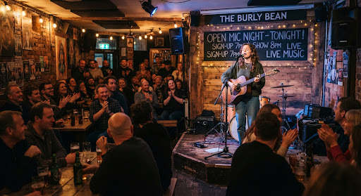 a singer with a guitar performing at an open mic night